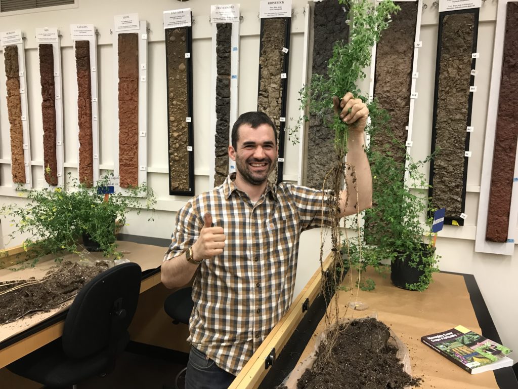 Joseph Amsili holding an alfalfa plant